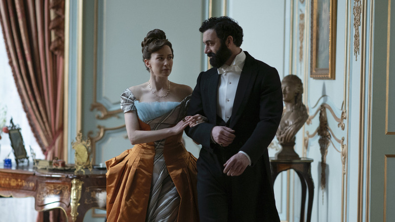 Carrie Coon as Bertha walking arm in arm with Morgan Spector as George in The Gilded Age