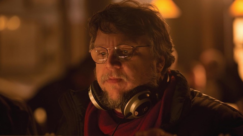 Guillermo del Toro wearing headphones on the Crimson Peak set