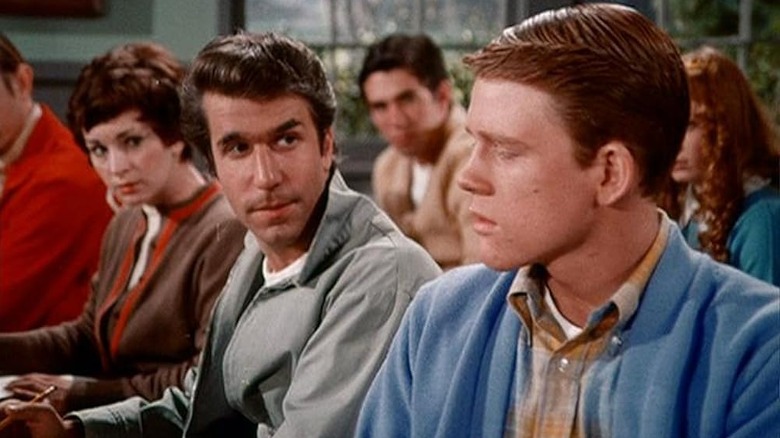 Henry Winkler as Arthur Fonzie Fonzarelli sitting next to Ron Howard as Richie Cunningham in class in Happy Days