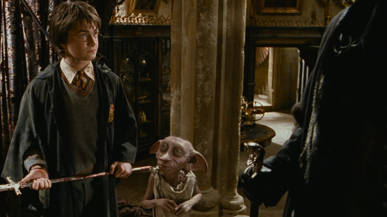Harry staring down Lucious Malfoy while Dobby stands beside him in Harry Potter and the Chamber of Secrets