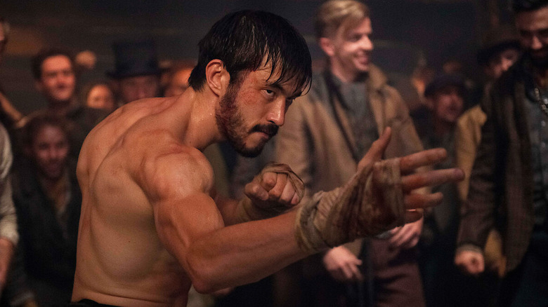 Ah Sahm, shirtless and covered in sweat, flexes his muscles and holds out a hand wrapped in bloody bandages as he fights in "Warrior"