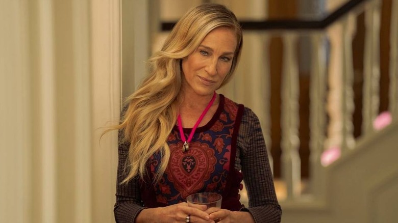 Carrie in a doorway wearing a red and black outfit in And Just Like That