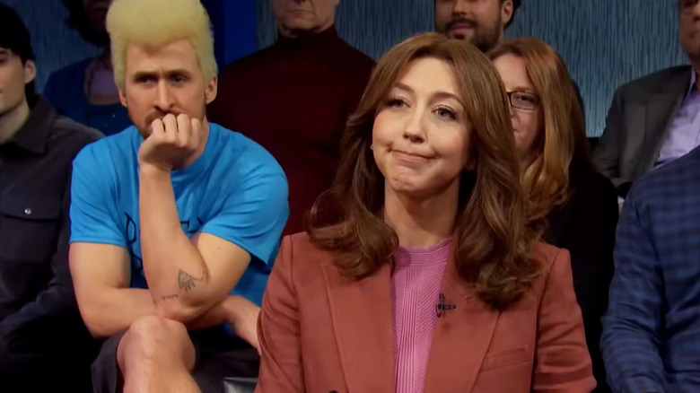 Heidi Gardner as a reporter on a News Nation show with Ryan Gosling in the background as Beavis on Saturday Night Live