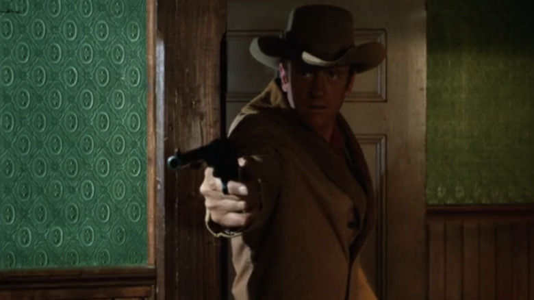 ஜேம்ஸ் ஆர்னஸ் மாட் டில்லோனாக கன்ஸ்லிங்கரில் துப்பாக்கியை சுட்டிக்காட்டுகிறார்