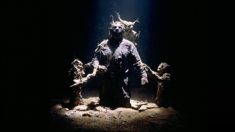 Jason being dragged into the ground by demonic monsters resembling roots.