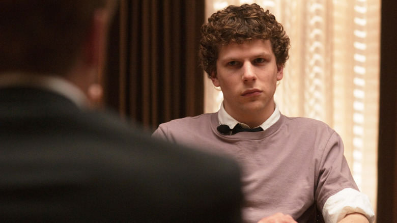 Jesse Eisenberg as Mark Zuckerberg seated at a table in The Social Network