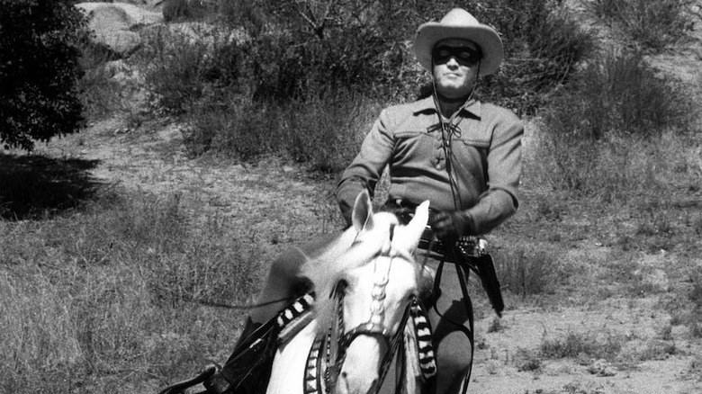 Lonely rainger on horseback, going down the hills