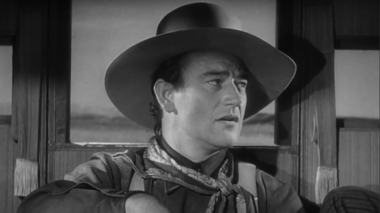 John Wayne as Henry, the Ringo Kid looks off to the side as he sits in the stagecoach in Stagecoach