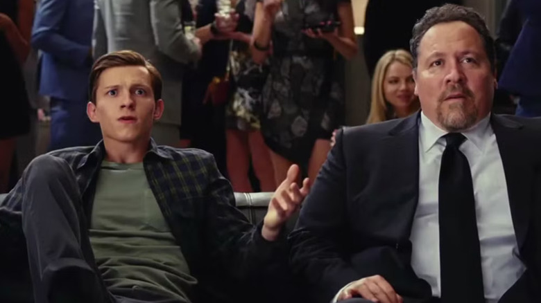 Peter Parker and Happy Hogan sitting on a couch in a Spider-Man movie