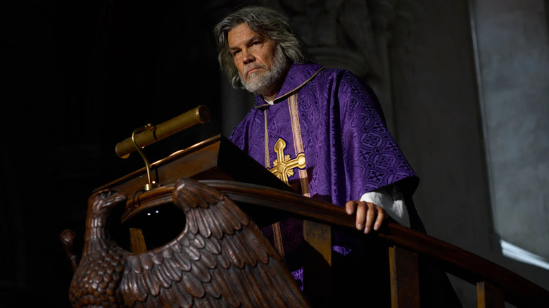 Josh Brolin as Jefferson Wicks standing at a podium in Wake Up Dead Man: A Knives Out Mystery