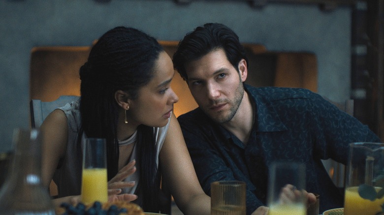 Nell and Jules whispering at the table in Something Very Bad is Going to Happen