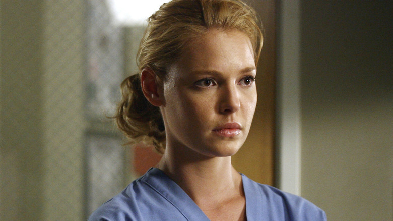 Izzie with her hair tied back in scrubs looking upset on Grey's Anatomy