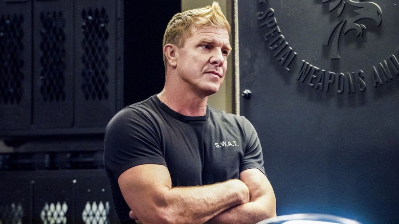 Kenny Johnson as Luca standing with his arms folded in the locker room in S.W.A.T.