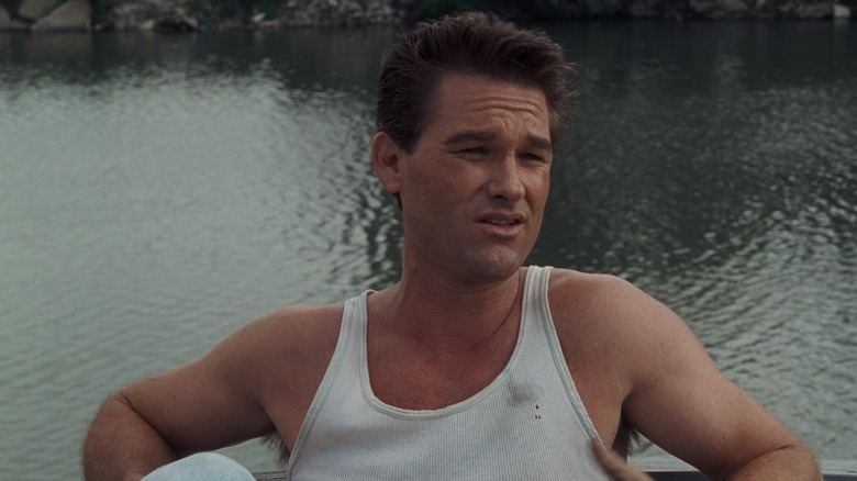 Kurt Russell as Stephen McCaffrey leaning back next to a body of water in Backdraft