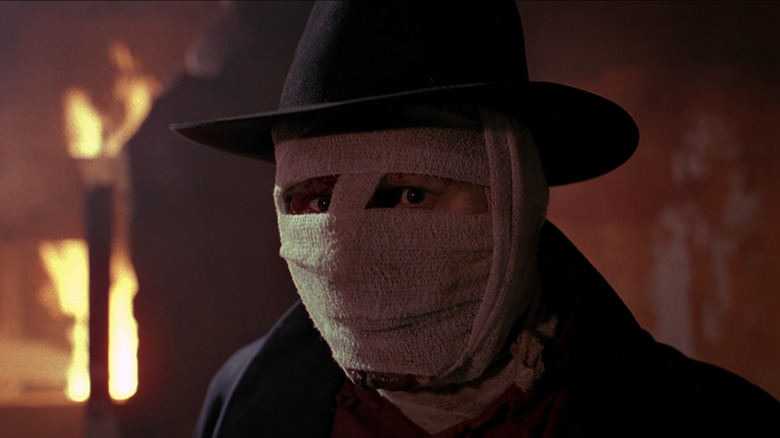 Darkman standing in front of a burning building in Darkman