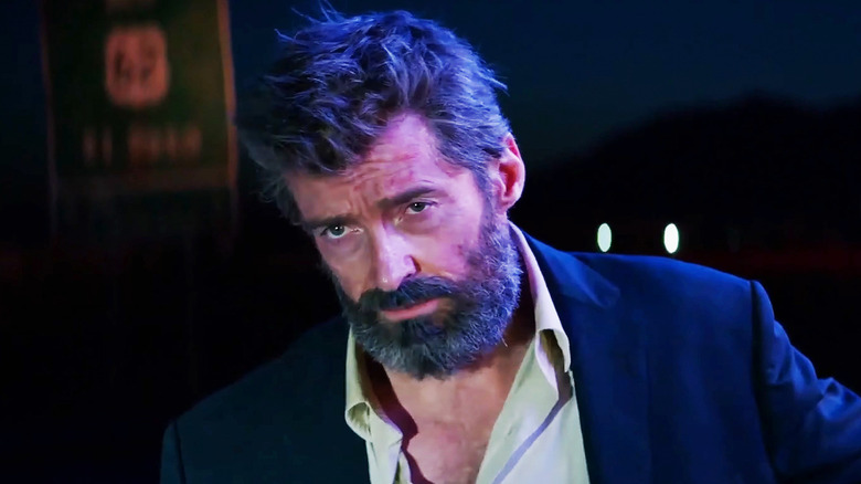 Logan by Hugh Jackman looks incredulous as he wears a costume jacket and an open shirt in Logan