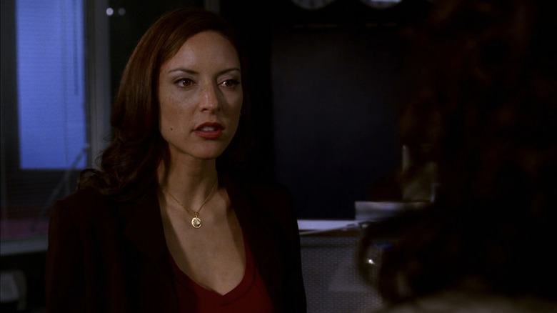 Lola Glaudini as Elle Greenaway stands in an office talking to someone with their back to the camera in Criminal Minds