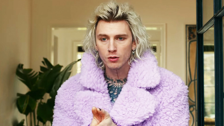 Colson Baker is seen standing in the doorway of his mansion in Jackpot!