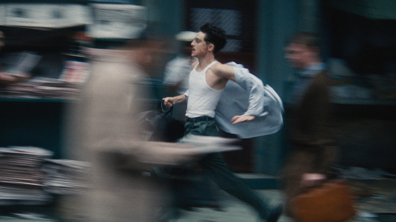 Timothée Chalamet running through the streets of New York City while holding a duffle bag in Marty Supreme