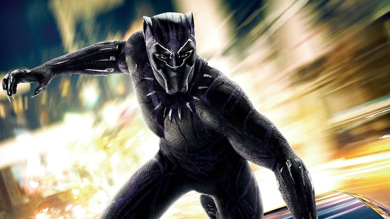 Black Panther stands on top of a fast-moving car in Black Panther