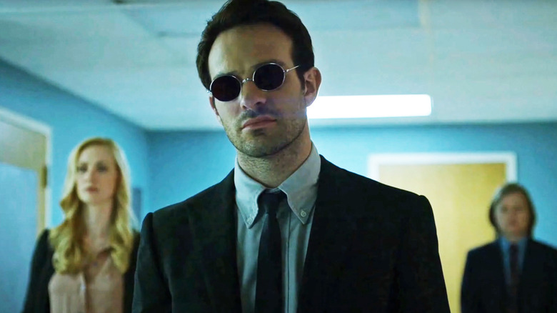 Charlie Cox's Matt Murdock stands in a hallway in front of Deborah Ann Woll's Karen Page and Elden Henson's Foggt Nelson in Daredevil