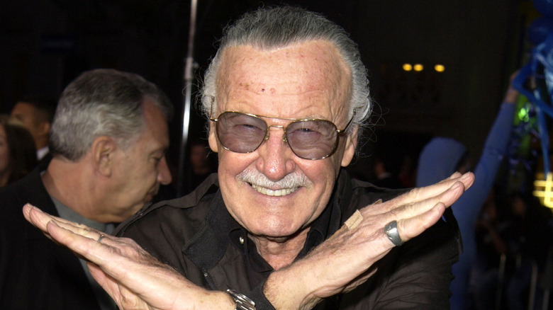 Stan Lee making X shape with his arms at the X2 premiere in 2003