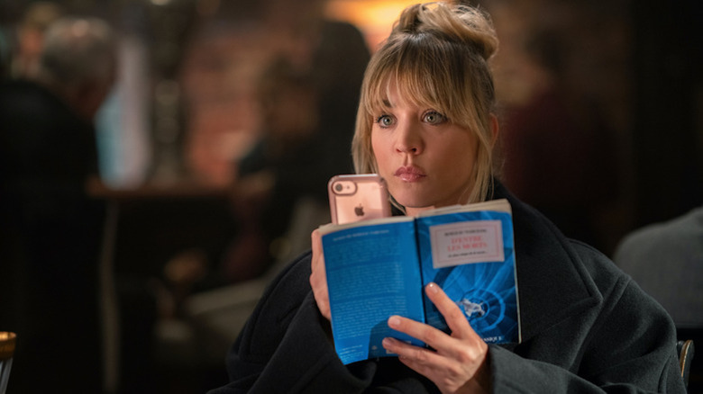 Kaley Cuoco como Cassie Bowden abre un libro en The Flight Attendant