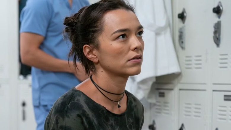 Mika looking up at someone in the intern locker room on Grey's Anatomy