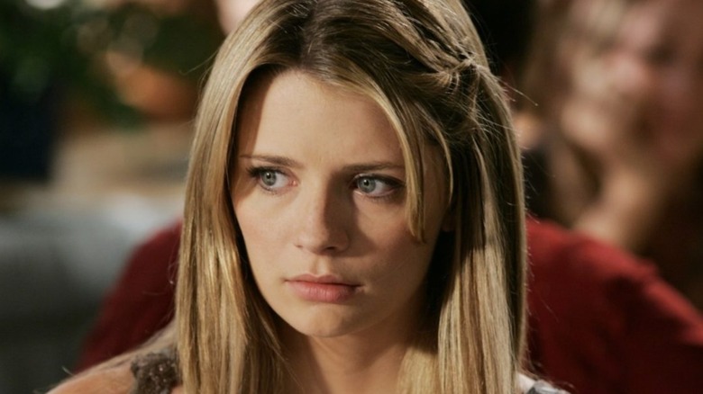 Marissa looks at something with a braid in her hair on OC