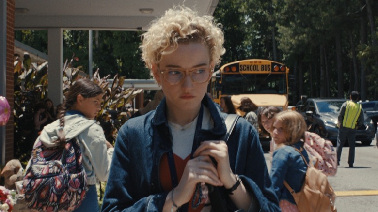Justine walking outside of the school looking shifty in Weapons