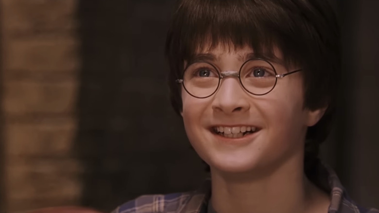 Daniel Radcliffe's Harry Potter smiles in closeup in Harry Potter and the Sorceror's Stone
