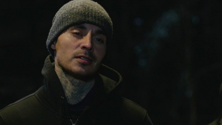 Manny Montana's Rio stands in a hoodie and beanie in the darkness in Good Girls