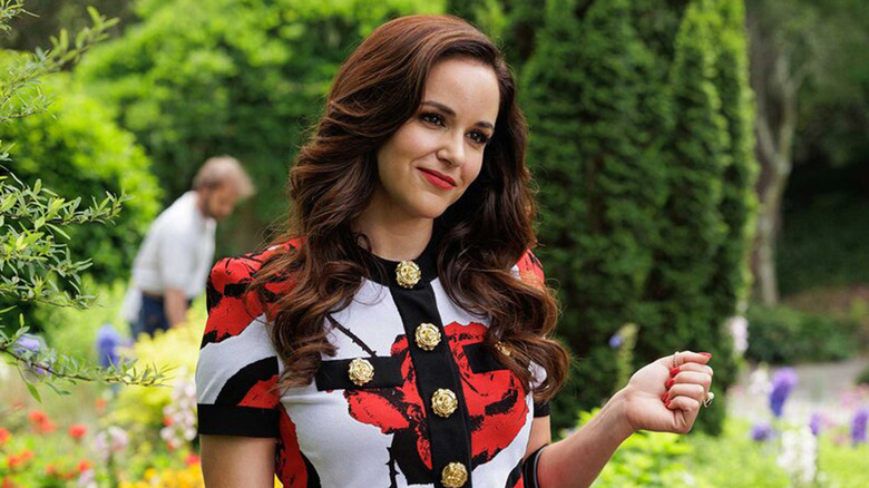 Melissa Fumero's Birdie smiles as she stands in a garden in Grosse Pointe Garden Society .jpg