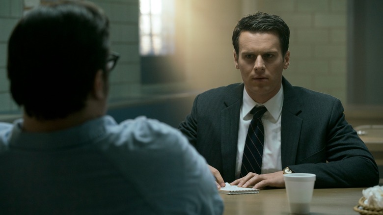 Jonathan Groff's Holden Ford sits opposite Cameron Britton's Ed Kemper at a prison meeting table in Mindhunter