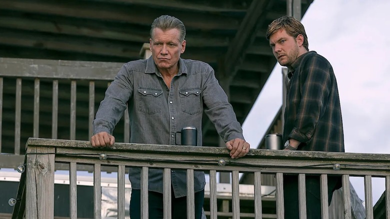 Holt McCallany as Harlan Buckley stands on a deck with Jake Weary as Cane Buckley in The Waterfront