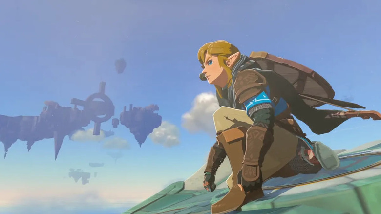 Link crouched on a wing gliding between sky islands in The Legend of Zelda: Tears of the Kingdom