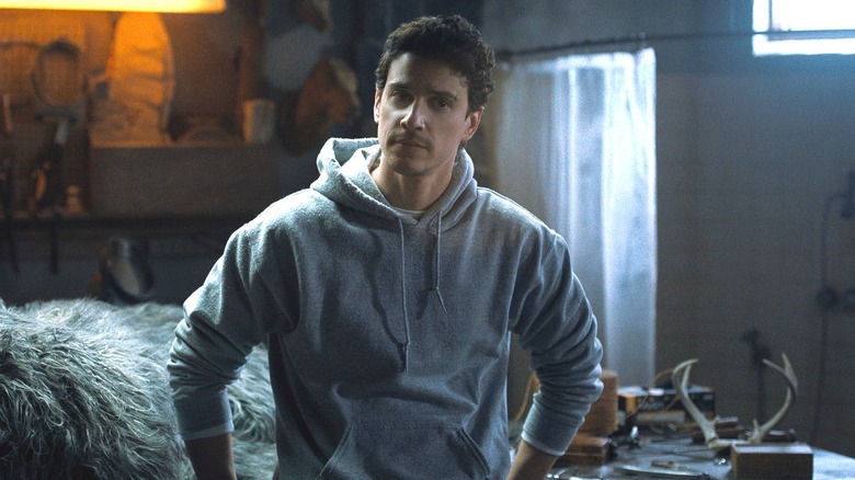 Nicky (Adam DiMarco) standing with his arms by his side on 