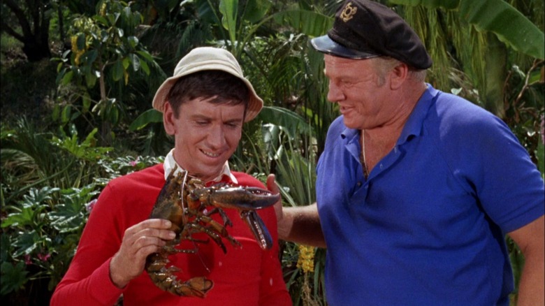 Gilligan holding a lobster next to the Skipper on Gilligan's Island