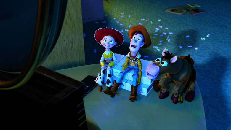 Jessie (Joan Cusack), Woody (Tom Hanks), and Bullseye watch an episode of Woody's Roundup on TV in Toy Story 2