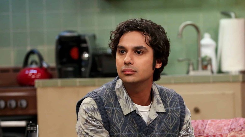 Raj on the couch wearing a sweater vest in The Big Bang Theory