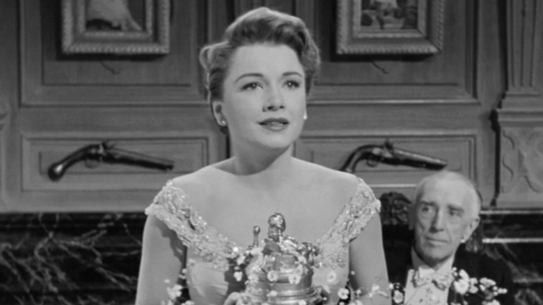 Eve Harrington giving an acceptance speech at a theater awards ceremony.