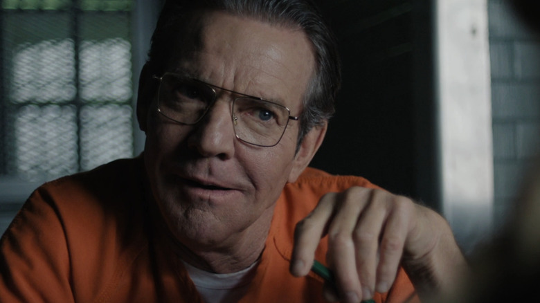 Dennis Quaid's Keith Hunter Jesperson smiles while wearing a prison jump suit in Happy Face