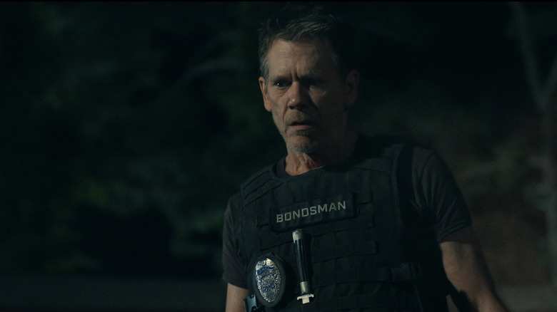 Kevin Bacon as Hub Halloran looks shocked as he stands in uniform in The Bondsman