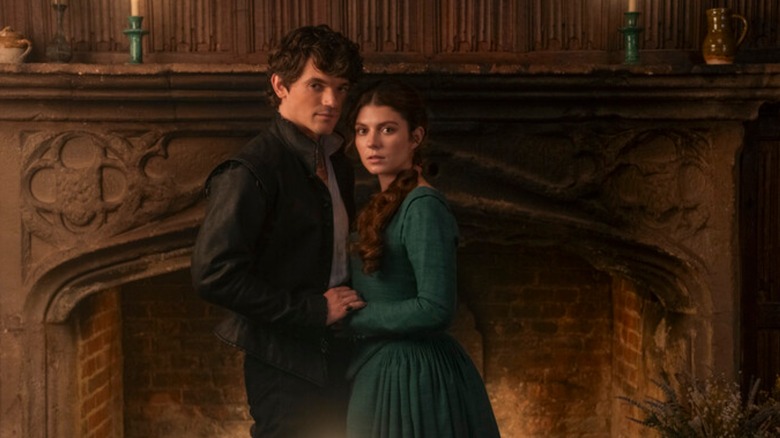 Edward Bluemel as Guildford and Emily Bader as Jane, clinging nervously to one another in front of a fireplace in My Lady Jane