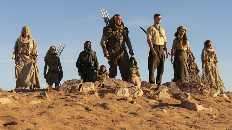 Multiple characters stand on top of sandy hill in Wheel of Time