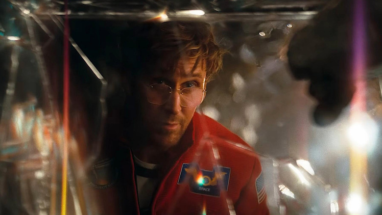 Ryan Gosling as Ryland Grace looking through a prism of light while James Ortiz as the voice of Rocky offers a fist bump in Project Hail Mary