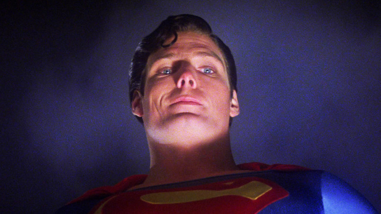 Christopher Reeve's Superman smiles as he's seen from a low angle in Superman