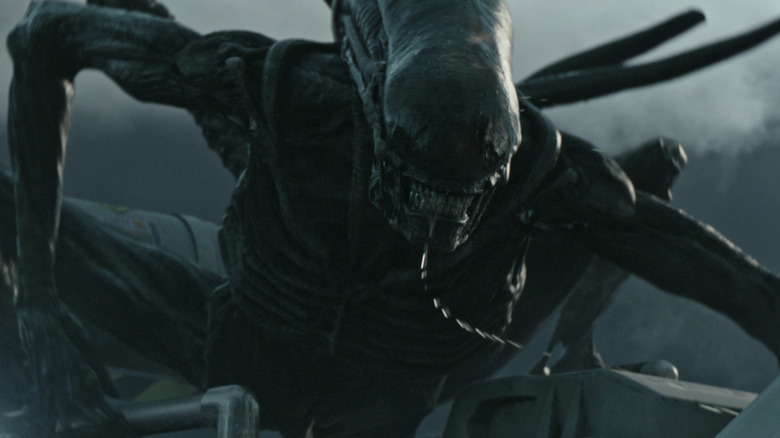 A Xenomorph climbing on the outside of a ship in Alien: Covenant