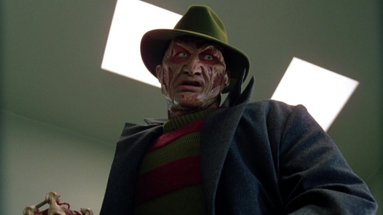 Robert Englund as Freddy Krueger wearing a coat and hat in Wes Craven's New Nightmare