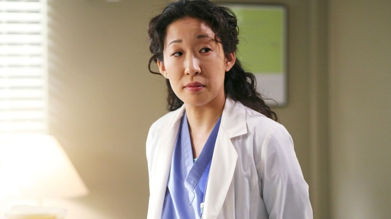 Cristina looking to the side in her white coat on Grey's Anatomy